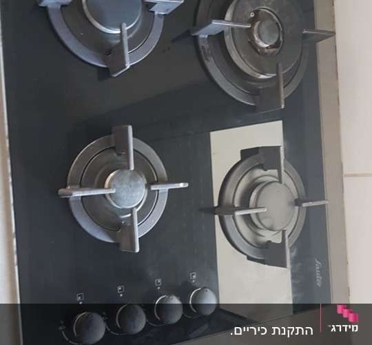 כיריים גז שחורות עם ארבעה מבערים וכפתורים